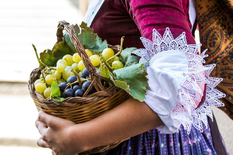 Frau in sardischer Tracht mit Weintrauben